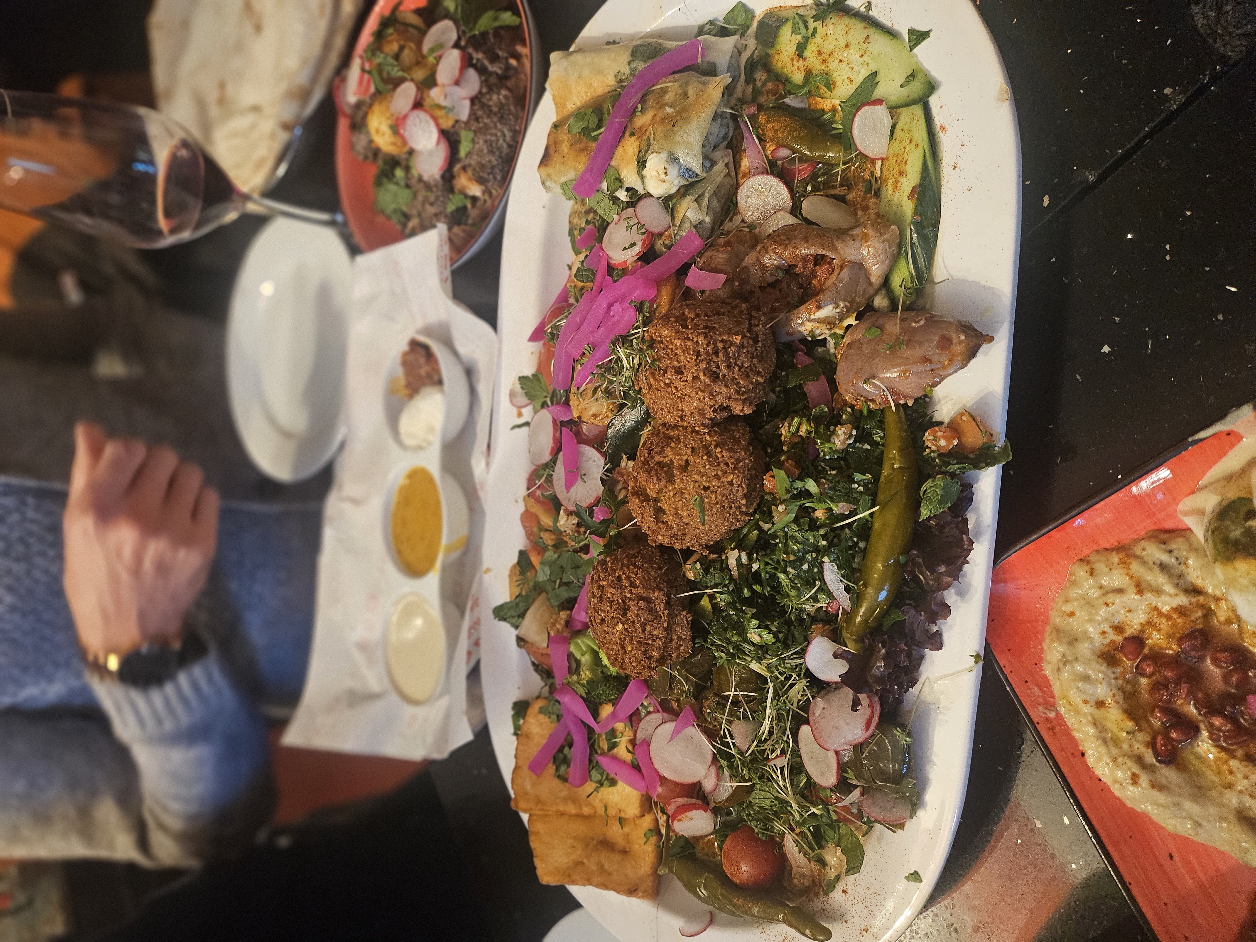 Abundant Middle Eastern mezze platter feast with fresh flatbreads, dips, and wine
