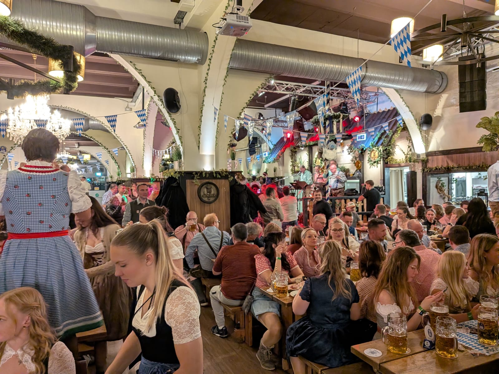 Bavarian beer hall interior in Berlin during Oktoberfest with long wooden benches and banners