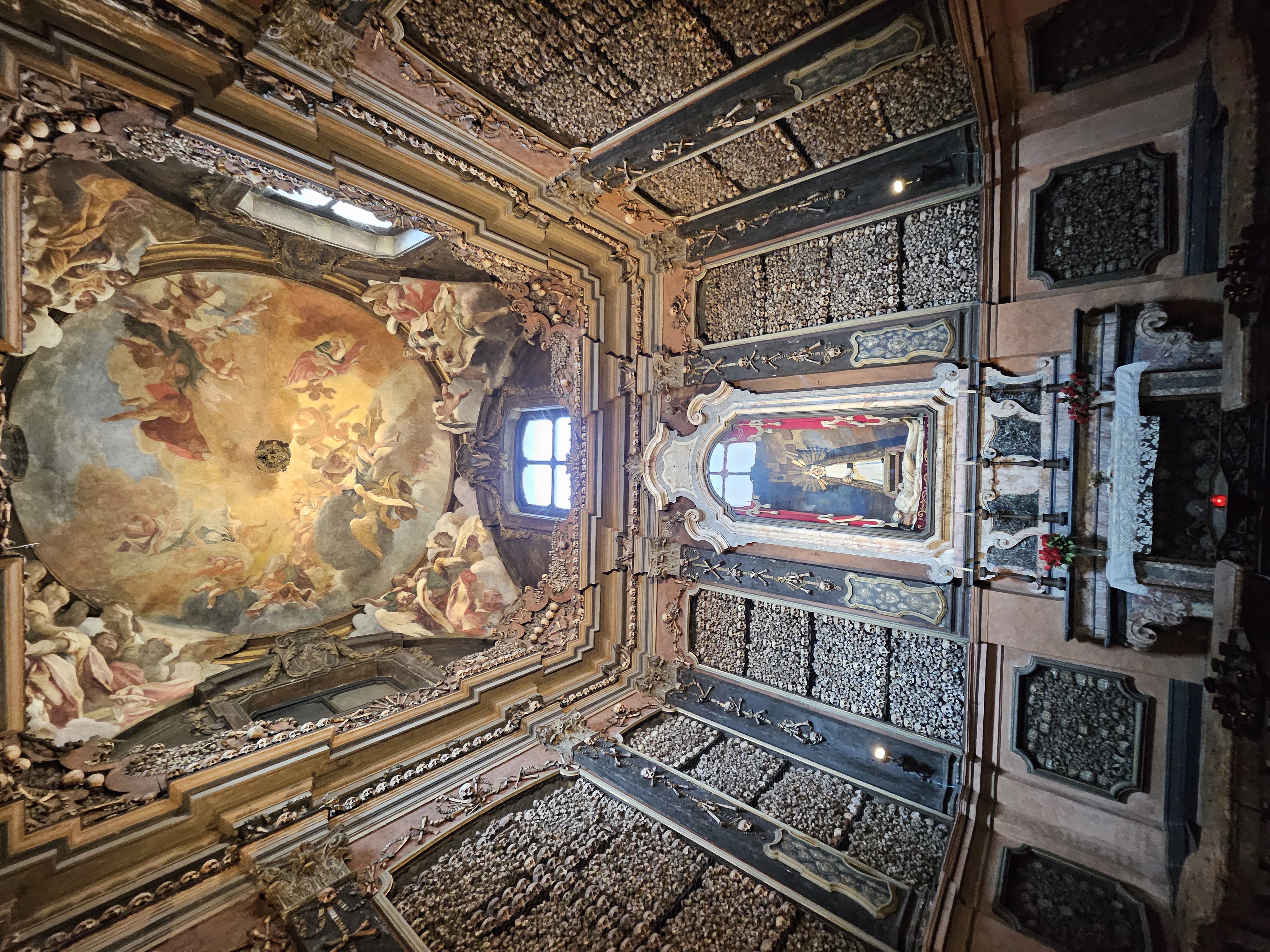 Walls lined with human skulls and bones inside the ossuary of Santuario di San Bernardino alle Ossa
