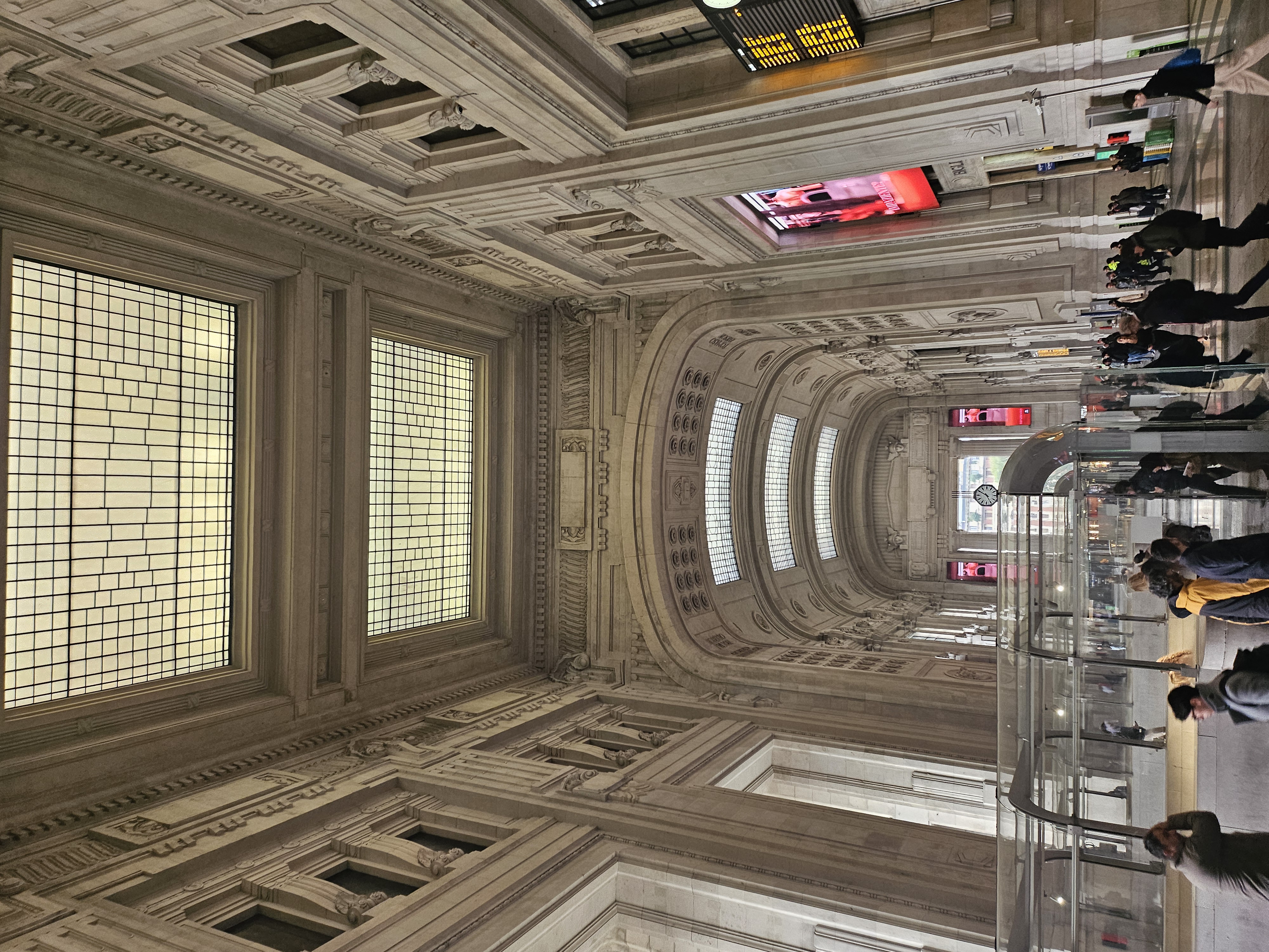 Soaring monumental stone architecture and glass roof of Milano Centrale railway station